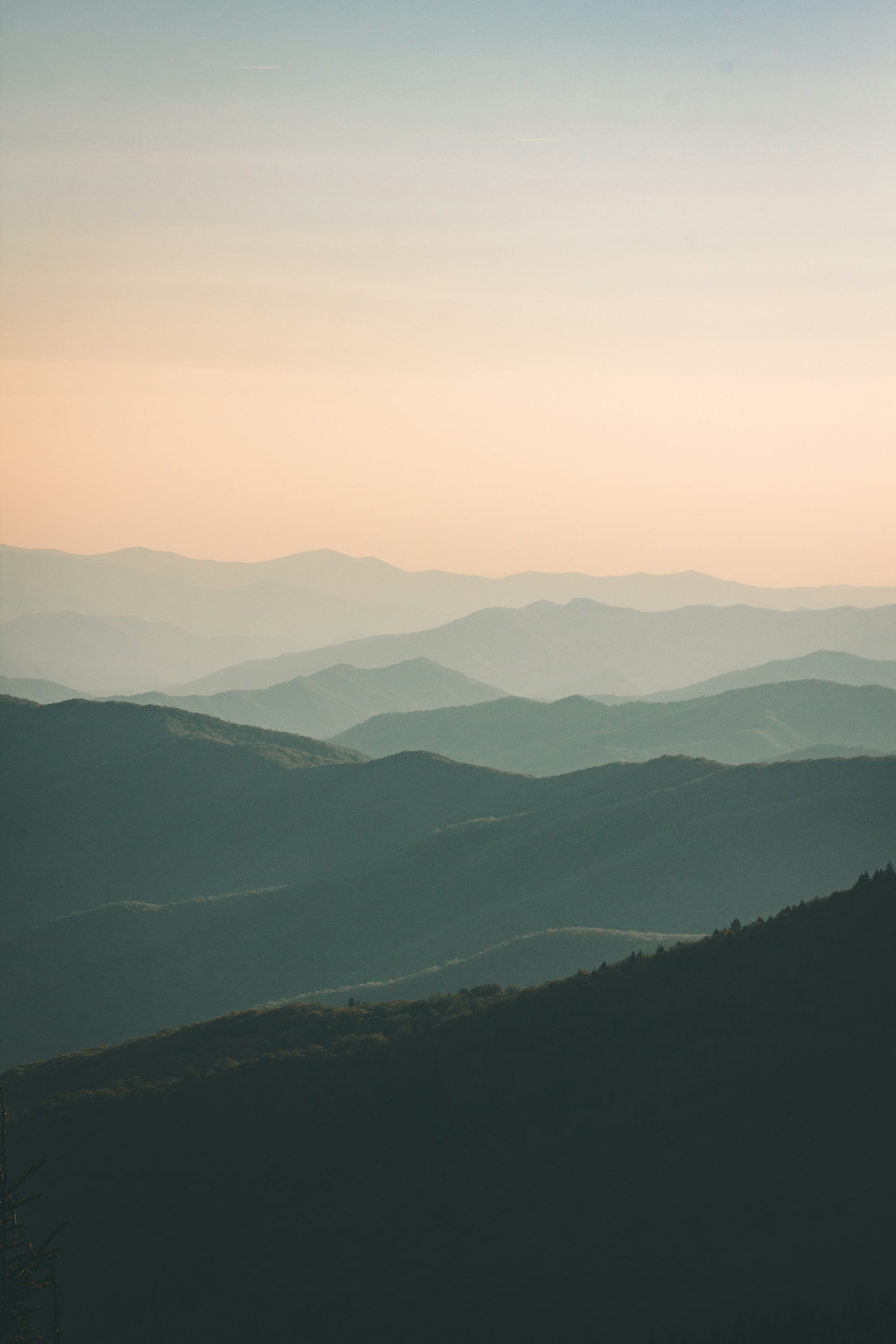 Layered mountain ridges in warm evening haze